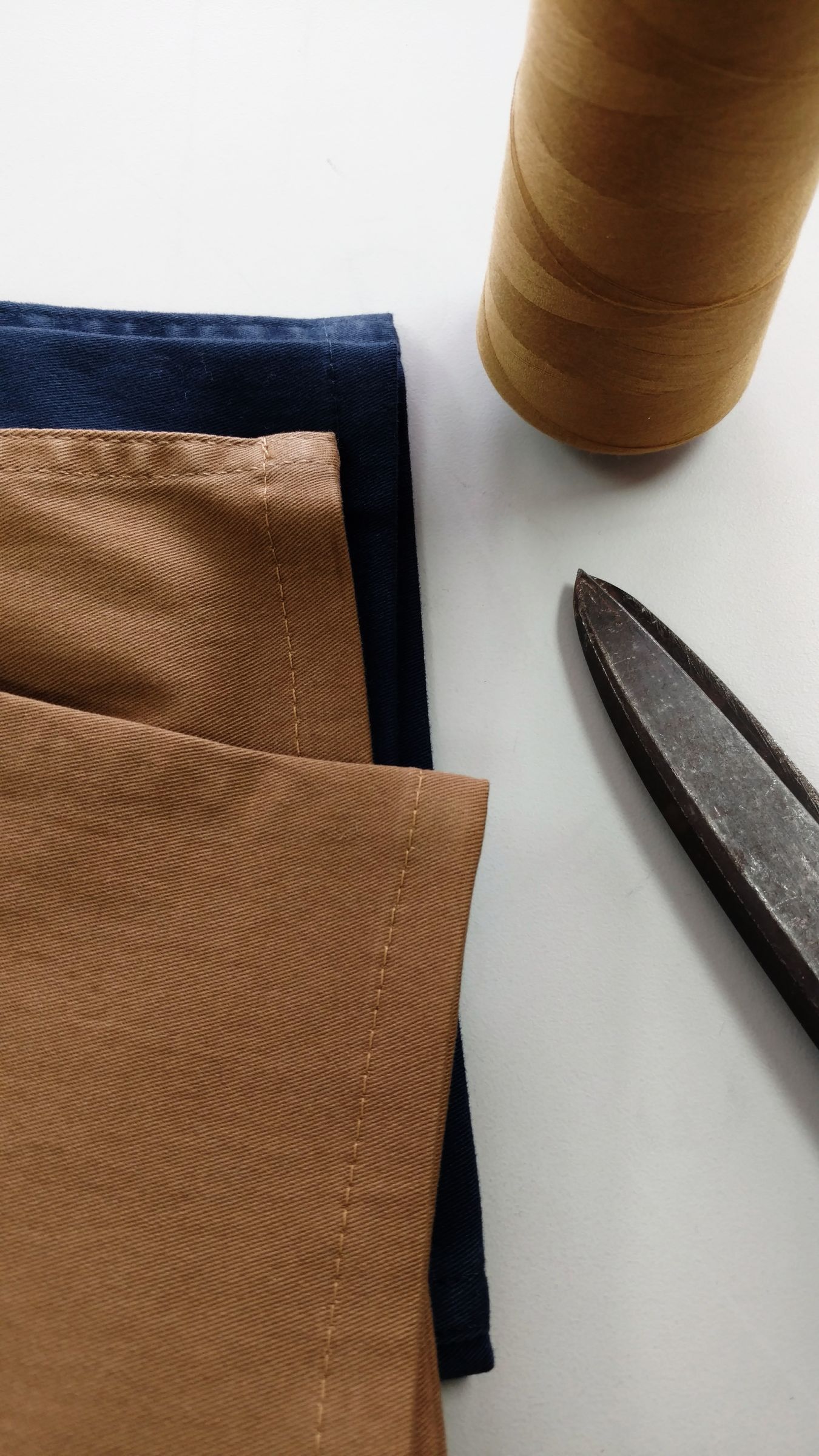 Fabric, a thread spool and shears on the work table
